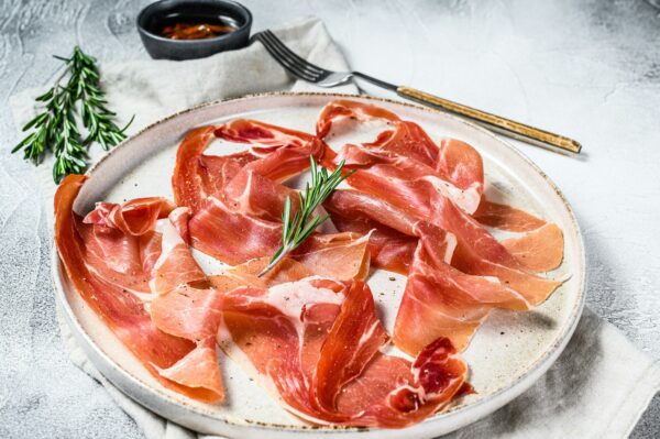 Spanish jamon Serrano, ham. Antipasto plate. Gray background, top view.