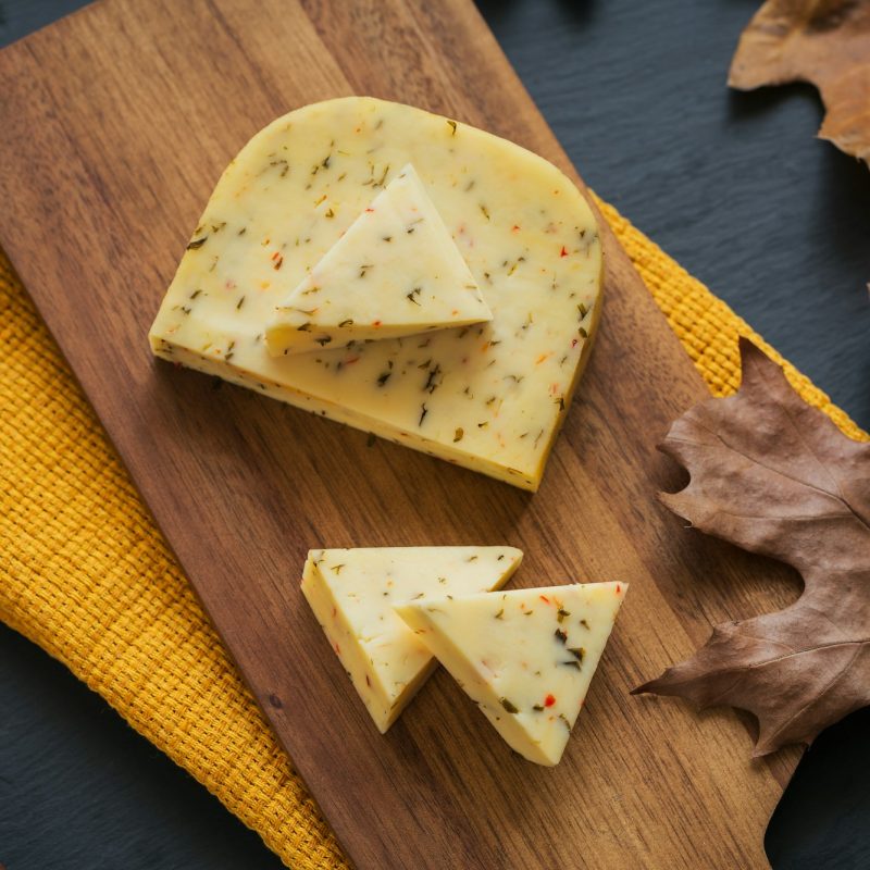 cheese-with-herb-in-a-cutting-board-on-dark-background-